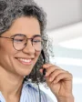 mulher falando por fone portátil e olhando computador
