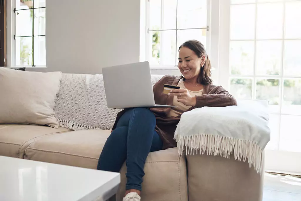 mulher com cartão de crédito e laptop