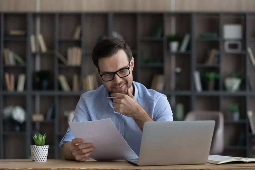 homem analisando dados em relatório de papel