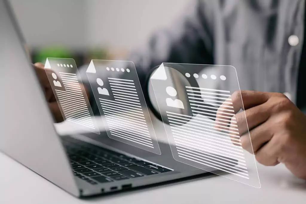 homem com lupa em computador e símbolos de formulários digitais
