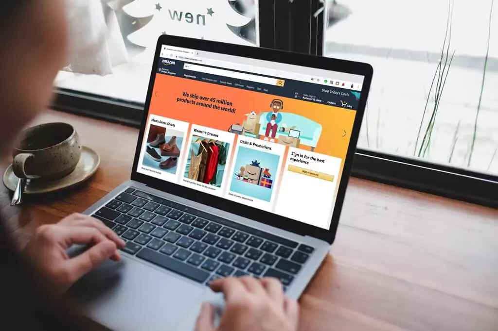 pessoa mexendo em site da amazon em laptop