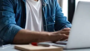 rapaz digitando em laptop