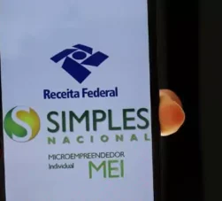 pessoa segurando celular com app do mei
