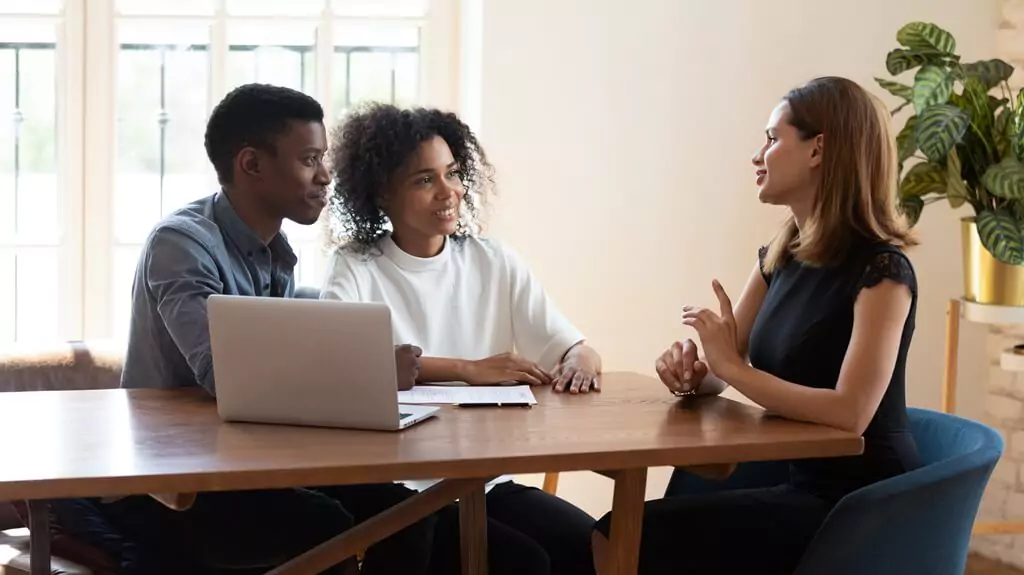 mulher falando com casal em reunião