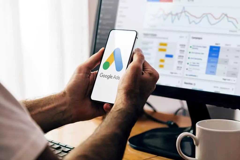 homem com celular abrindo google ads