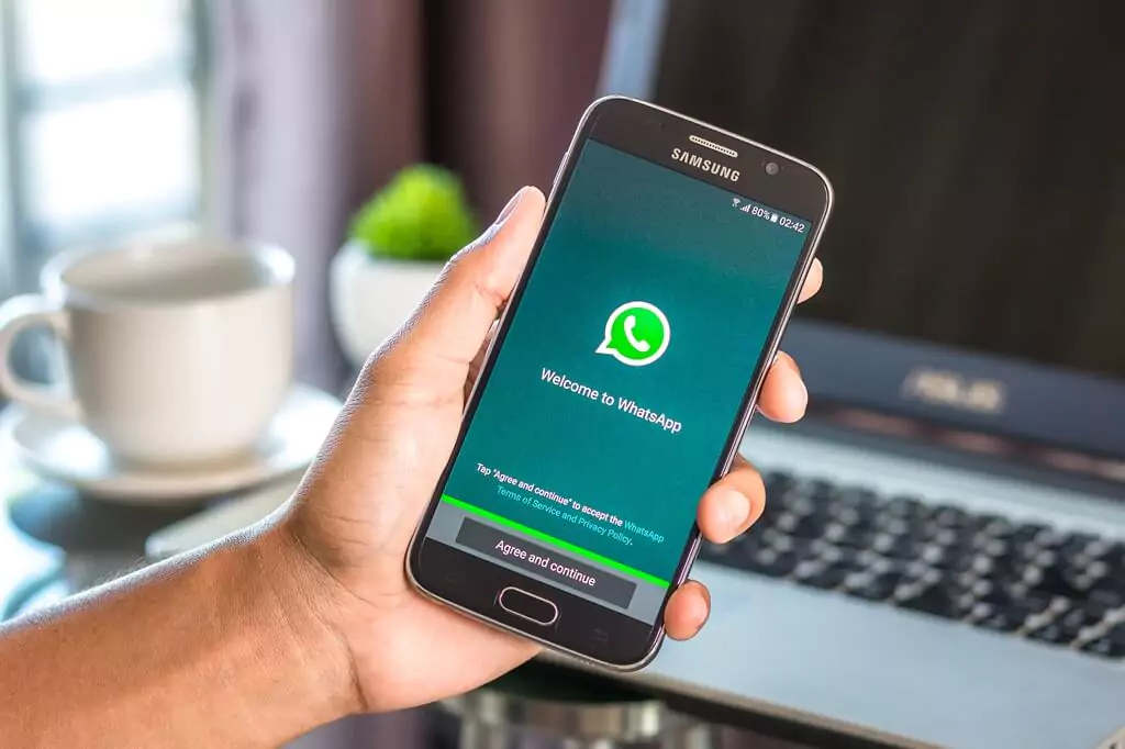 mão segurando celular com whatsapp